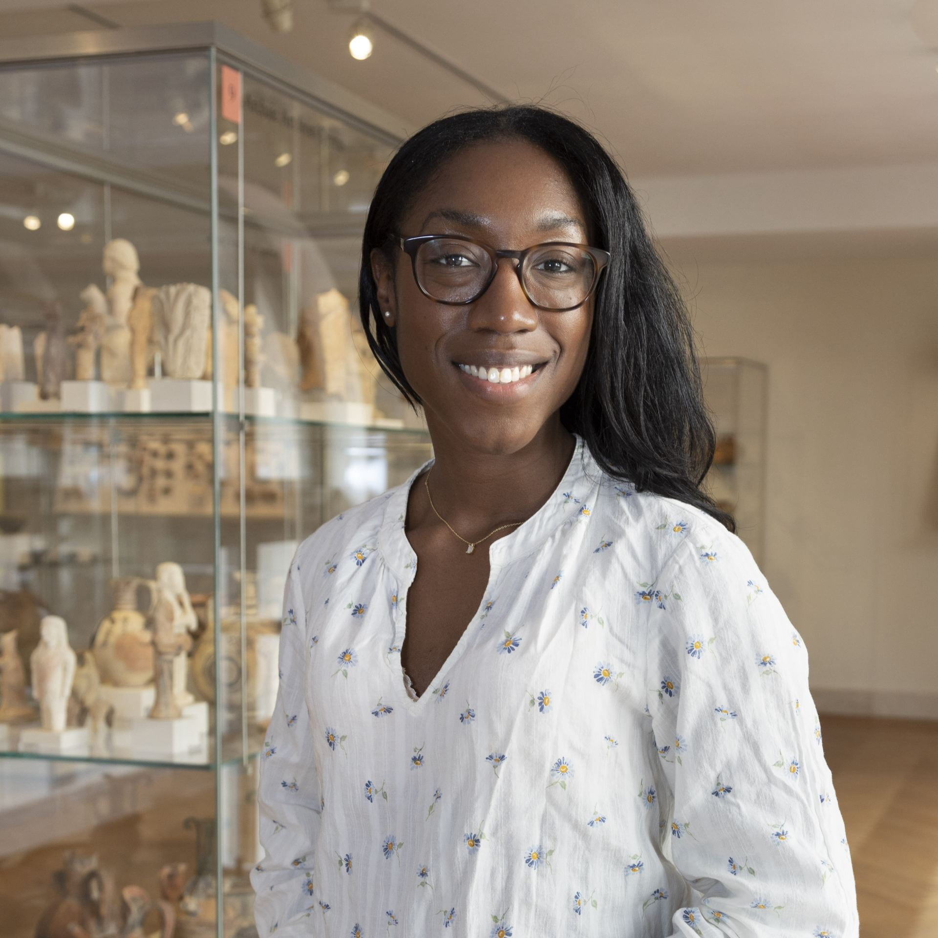 young woman with glasses in a museum gallery