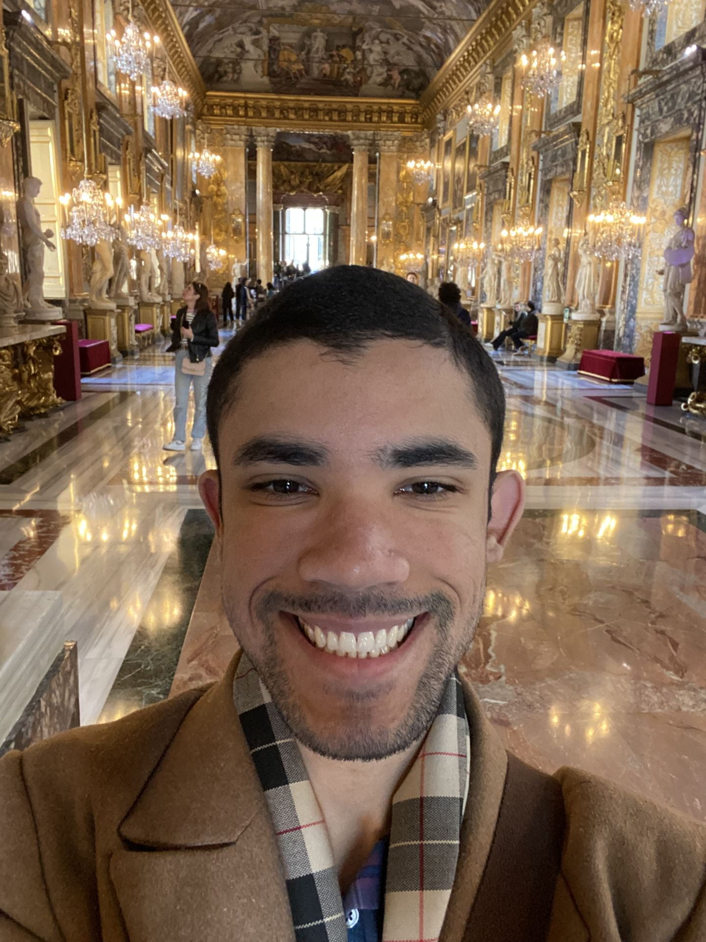 a young man with a mustache and beard in a Baroque Hall