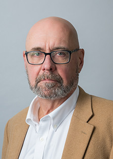 portrait of a man with a beard and glasses, who is also bald