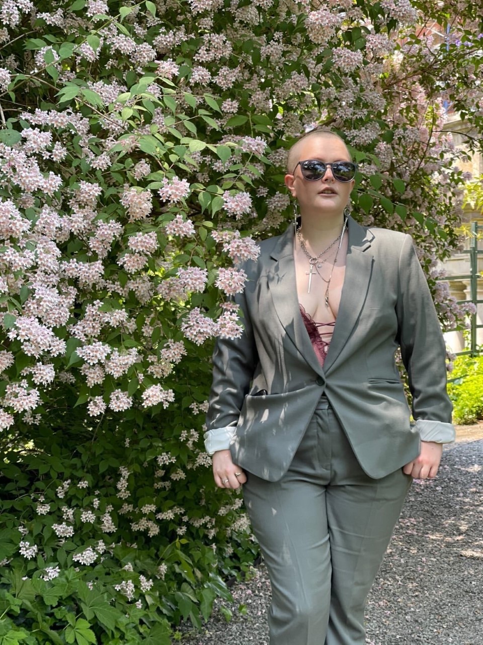 Kelley Bullock '16 standing underneath a flowering shrub