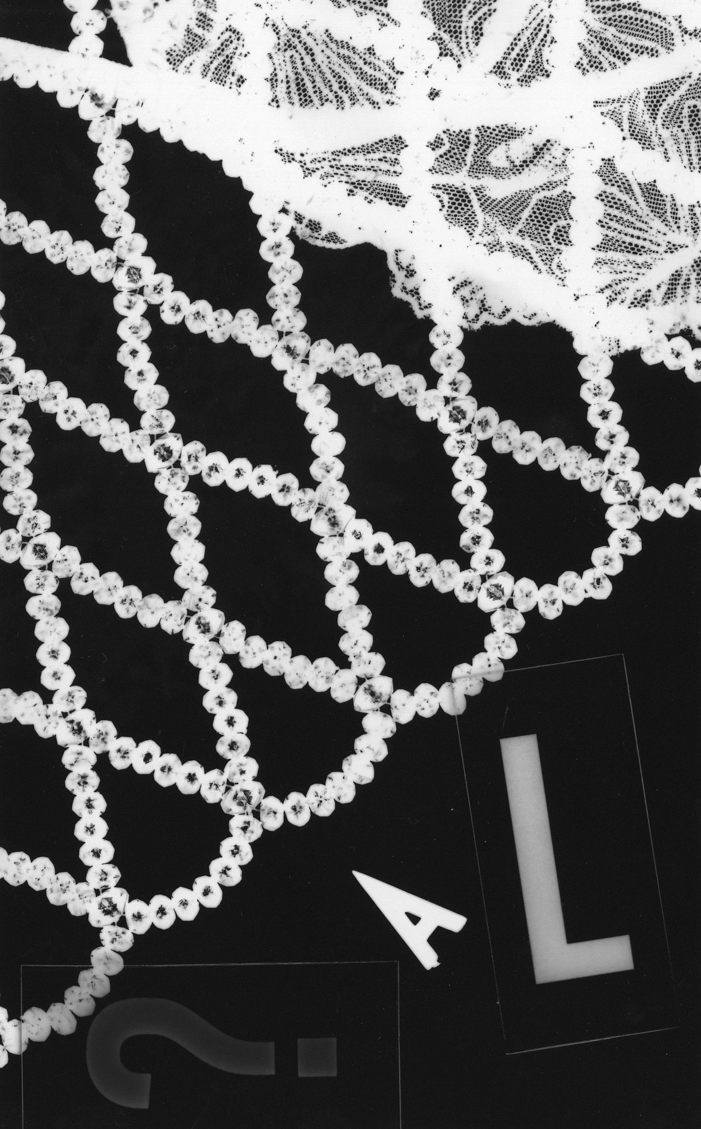 a photogram of lace, rope and letters