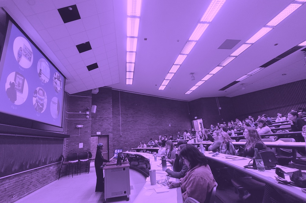 student standing at a podium presenting in a lecture hall