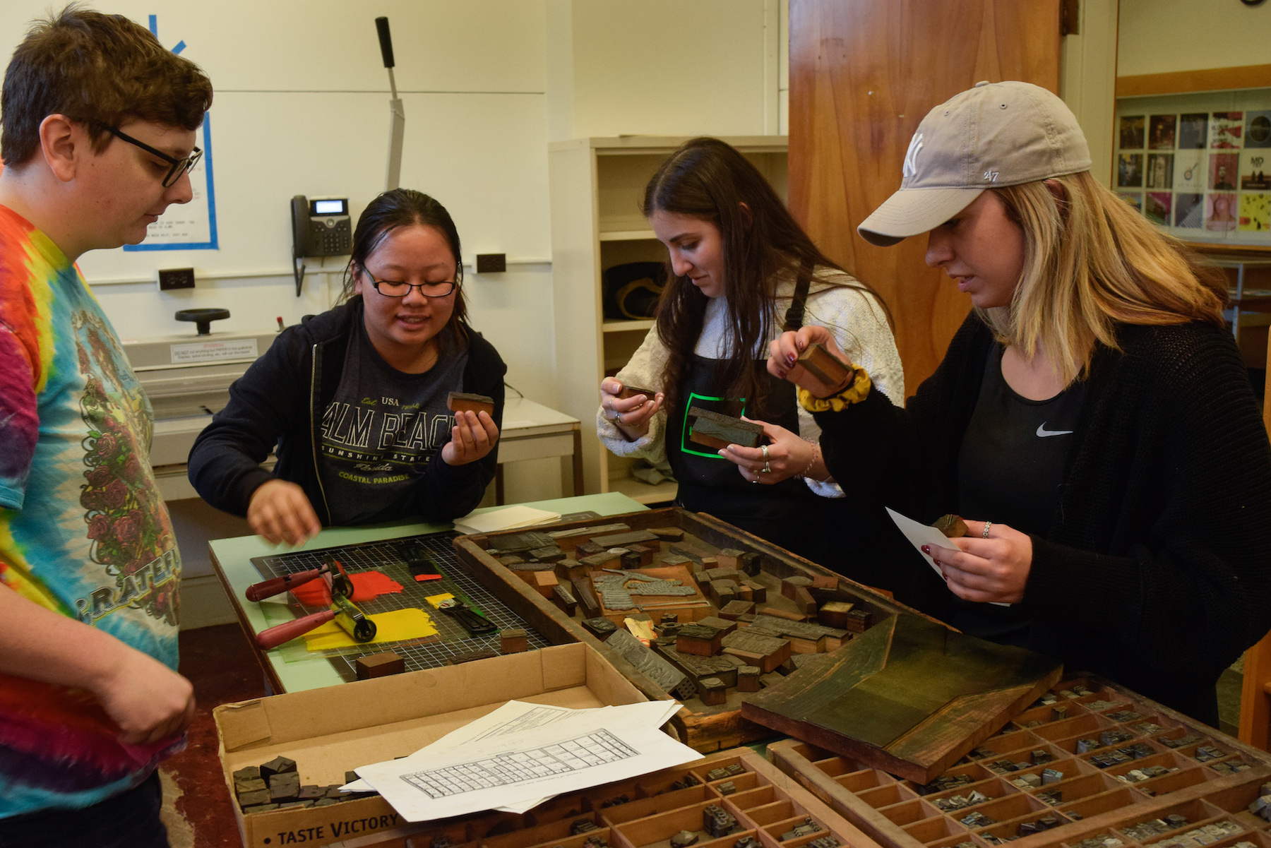 college students sorting through metal type cases in a studio