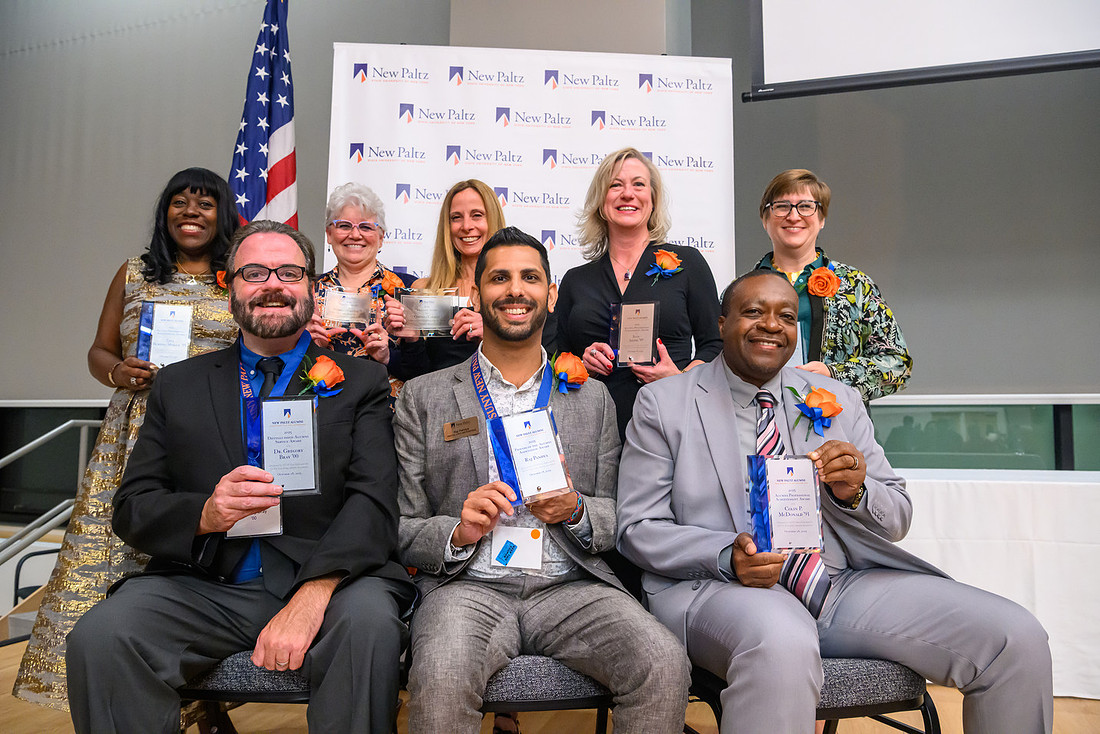Awards ceremony recipients pose with their awards.