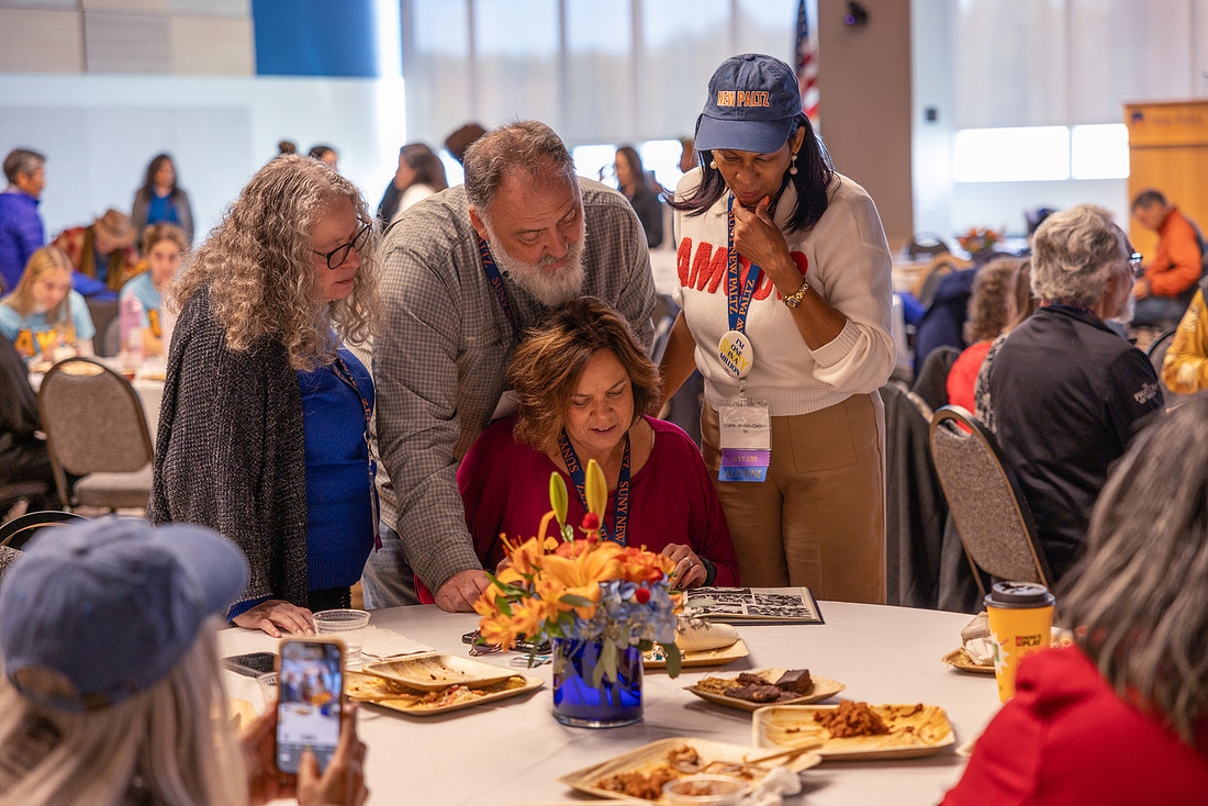 Folks gather around a yearbook.