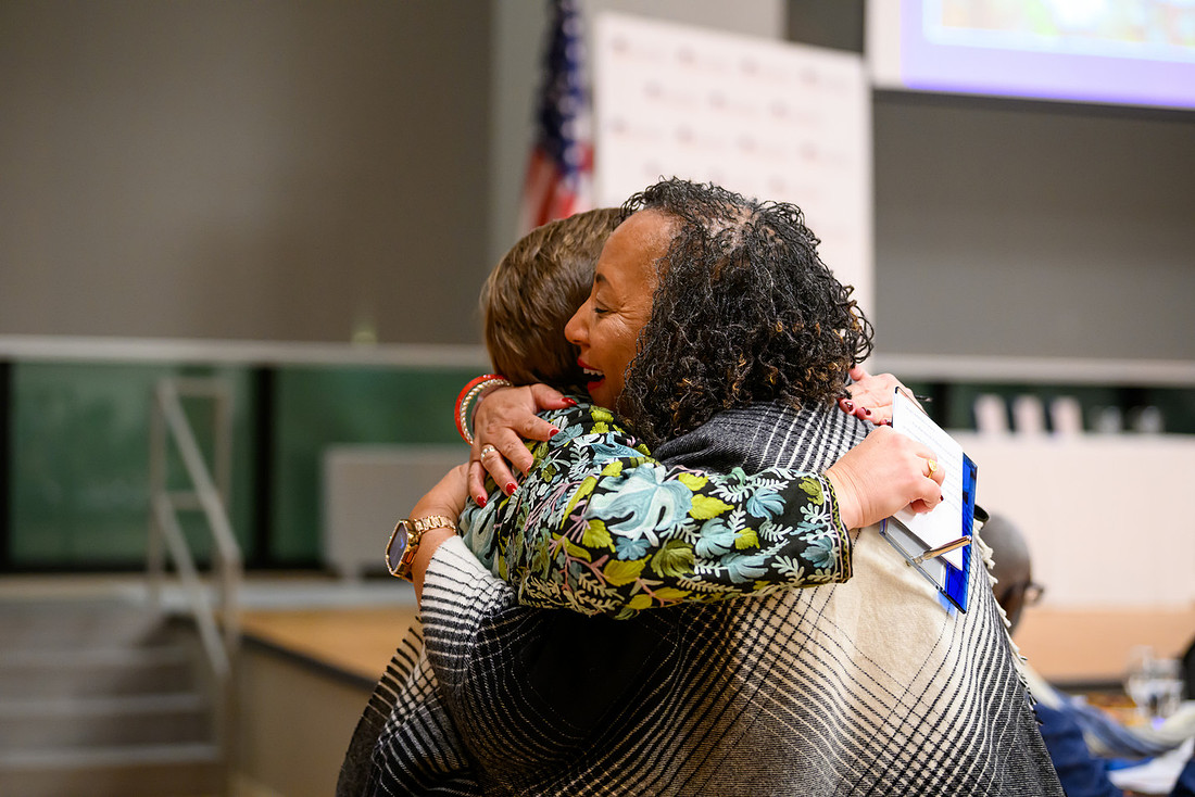 Awards ceremony recipients hug.