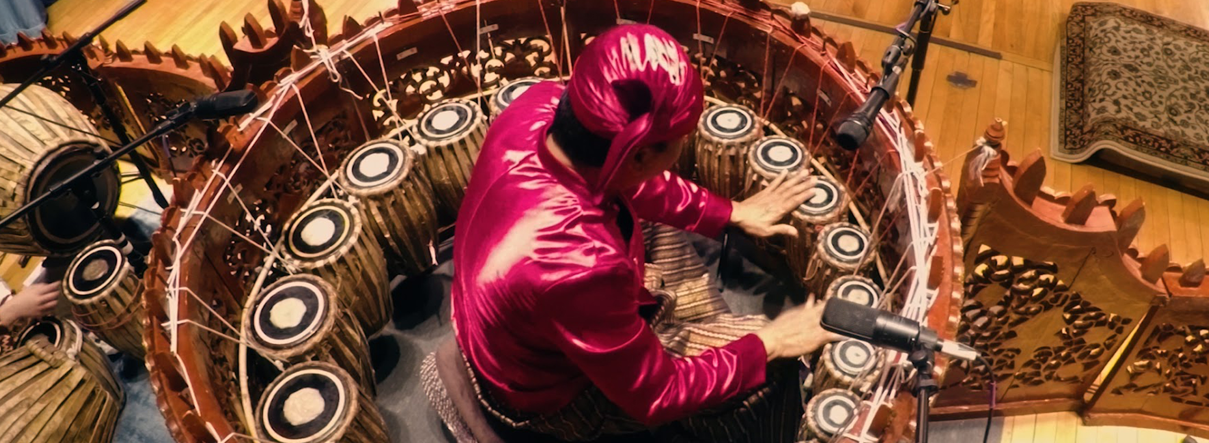 performer surrounded by drums